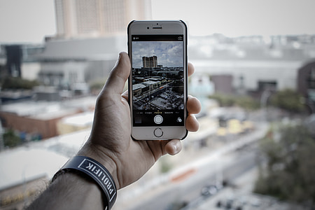 person taking photo of buildings with silver iPhone 6 thumbnail