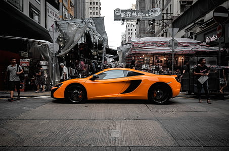 orange supercar along street at daytime thumbnail