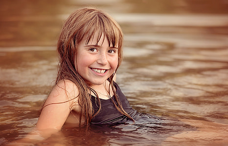 girl swimming on body of water thumbnail