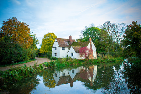 white and brown house beside body of water and road during daytime thumbnail