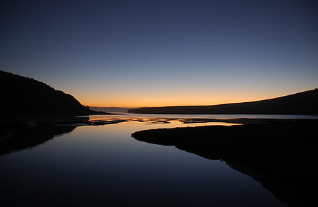 silhouette photography of body of water during golden hour thumbnail