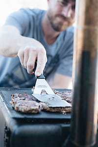 Man In Grey Crew-neck Shirt Frying Burgers thumbnail