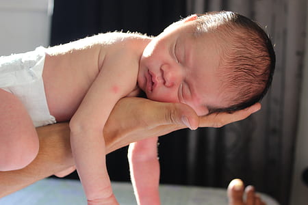 baby sleeping on person's hand thumbnail