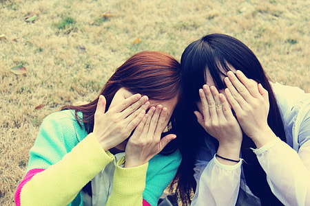 two women covering their faces thumbnail