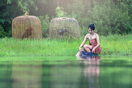 woman washing clothes on lake thumbnail