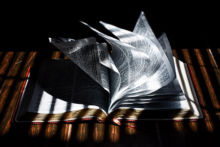 close photo of an open book on brown wooden table top thumbnail
