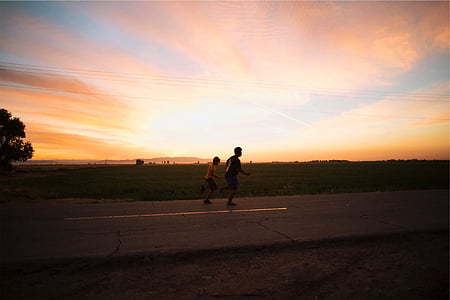 two boys running on road during golden hour thumbnail