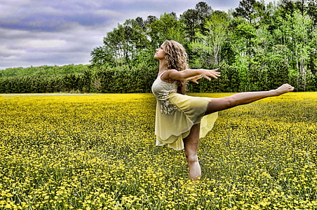 woman dancing on yellow rapeseed flower field during daytime thumbnail