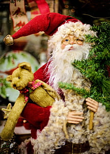 macro photography of ceramic Santa Claus holding bear figurine thumbnail