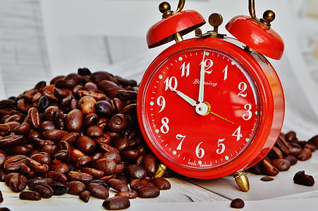 red and gold alarm clock beside coffee beans thumbnail