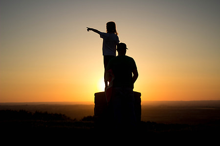 silhouette photo of man and girl during golden hour thumbnail