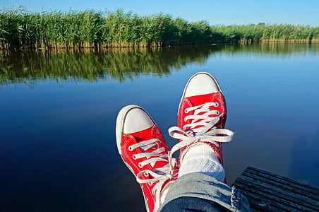 person wearing red-and-white Converse All-Star low-top shoes thumbnail