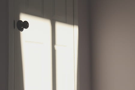 closed white door near white wall thumbnail