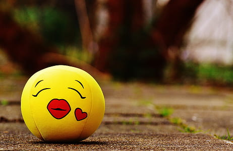 yellow and red kiss emoji stress ball in tilt shift photography thumbnail