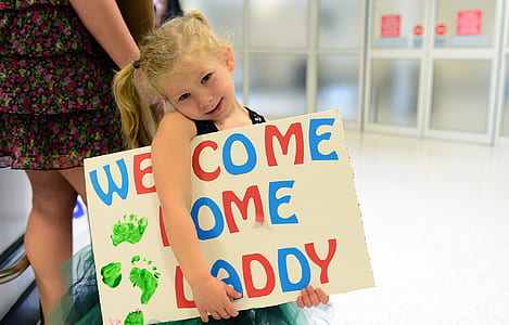 girl holding welcome home daddy signage thumbnail