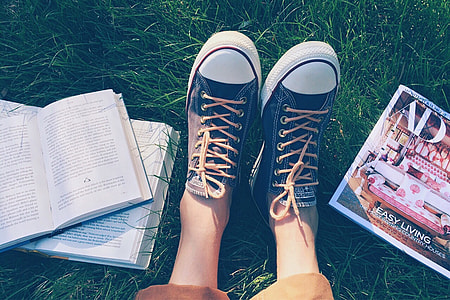 person wearing sneakers sitting on green grass field thumbnail