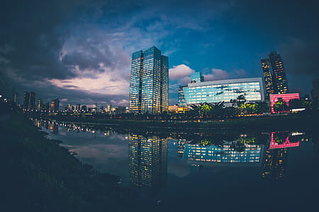 cityscape near lake under cloudy sky thumbnail
