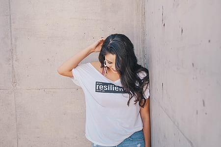 woman leaning on wall during daytime thumbnail