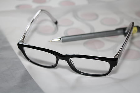 black framed eyeglasses near gray pen on white printer paper thumbnail