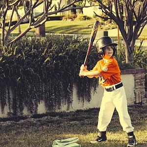 boy in orange and white baseball jersey readying bat for a swing thumbnail