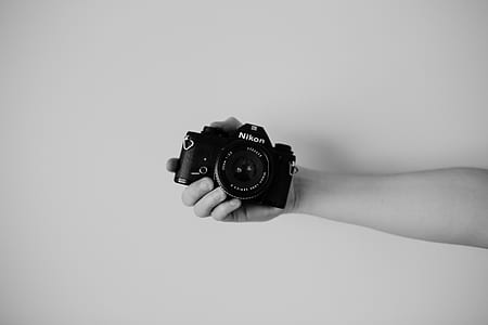 person holding Nikon camera thumbnail