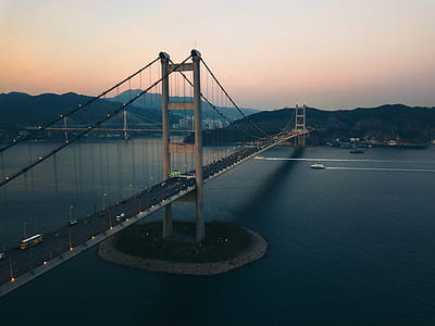 three boats crossing under bridge during golden hour thumbnail