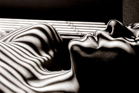 grayscale photo of person under stripe shadows thumbnail