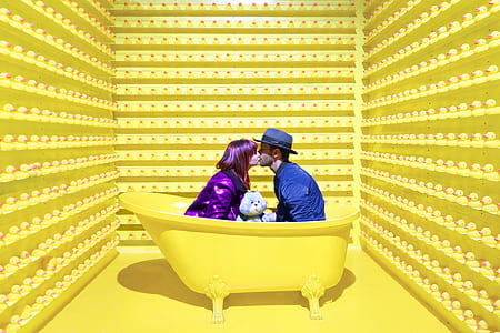woman wearing purple suit and man wearing blue suit kissing each other thumbnail