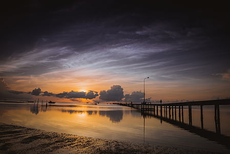 sunset on body of water with dock thumbnail