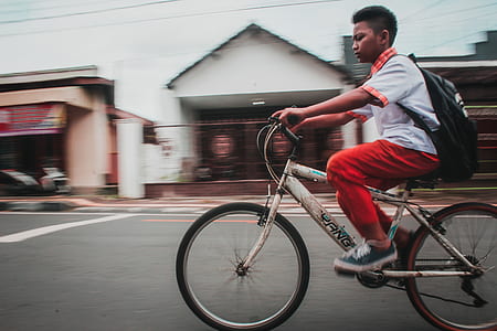boy in school uniform riding bicycle thumbnail