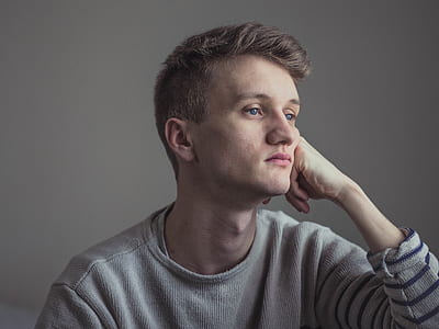 woman wearing gray crew-neck long-sleeved shirt near gray wall thumbnail