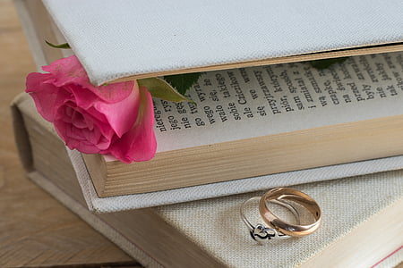 gold-and-silver-colored rings beside book thumbnail