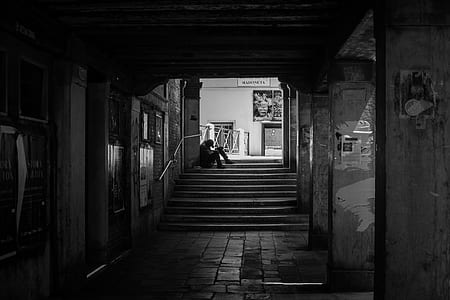 grayscale photo of person sitting on stair thumbnail