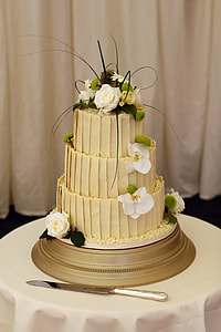 3-layered floral cake on white table in front of white curtain thumbnail