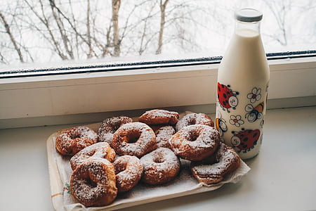 Doughnuts and Milk Bottle Near Clear Glass Window thumbnail