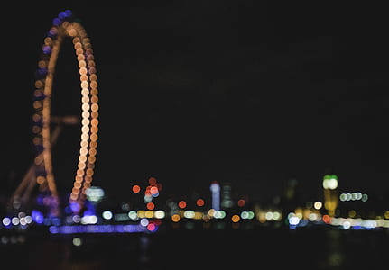 bokeh photography of ferris wheel and city lights at nighttime thumbnail