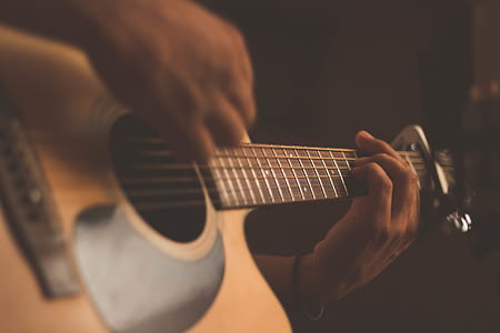 closeup photo of person playing guitar thumbnail