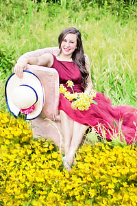 woman wearing maroon sleeveless dress while seating on beige suede armchair thumbnail