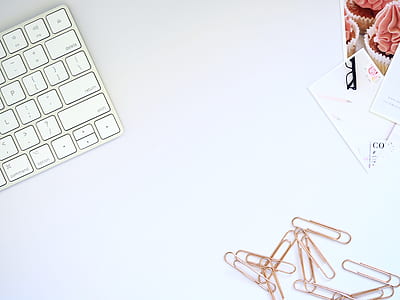 paper clips near white computer keyboard on white desk thumbnail