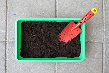 red shovel on top of green plastic bin thumbnail