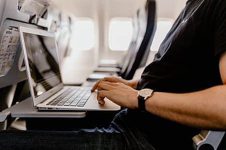 Unrecognizable man with notebook sitting inside an airplane thumbnail