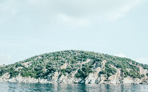 green mountain near body of water during daytime thumbnail