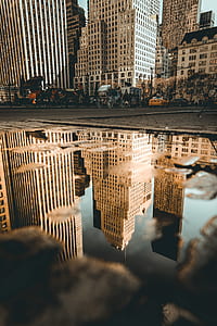 reflection photo of brown buildings on water during daytime thumbnail