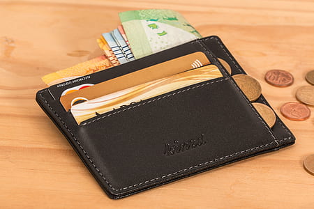 black leather card holder on brown surface thumbnail