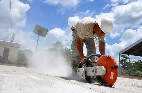 person holding red and gray concrete saw thumbnail