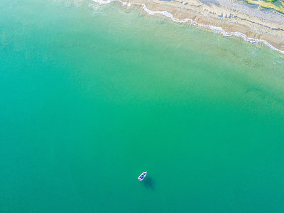 aerial photograph of boat approaching to shore during daytime thumbnail