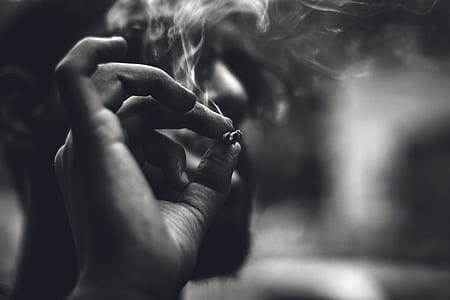 gray scale photo of man holding cigarette thumbnail