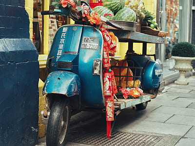 blue motor scooter loaded with fruits thumbnail