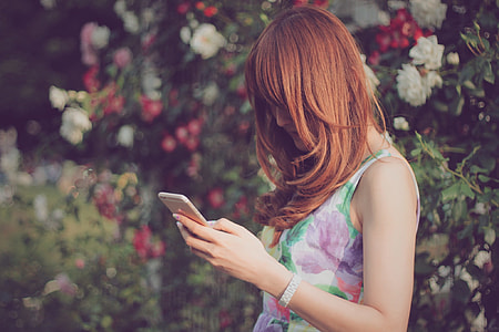 woman wearing floral sleeveless top holding gold iPhone 6 thumbnail