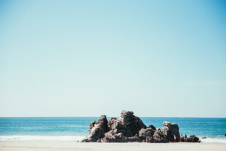 A rocky seashore in sunlight with horizon in the background thumbnail